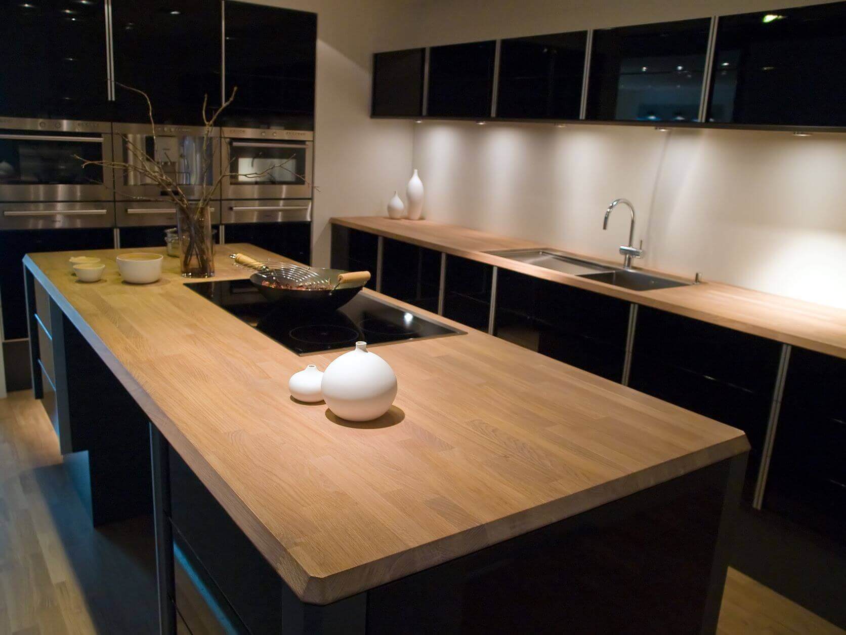trendy kitchen with natural wood island and black hi gloss cabinets